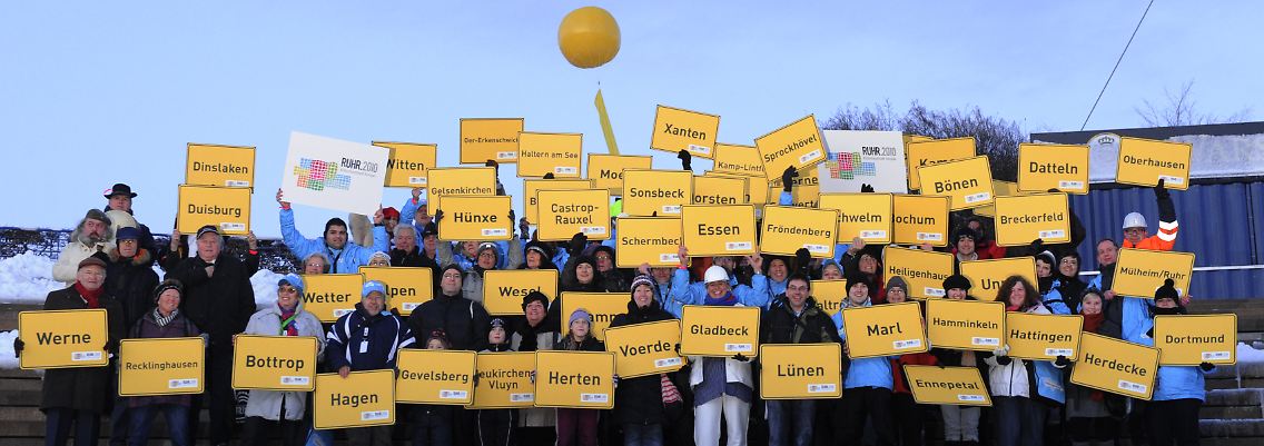 Menschen mit Ortschildern von Ruhrgebietsstädten beim Finale der Kulturhauptstadt Ruhr.2010 auf der Zeche Nordstern in Gelsenkirchen am 18. Dezember.