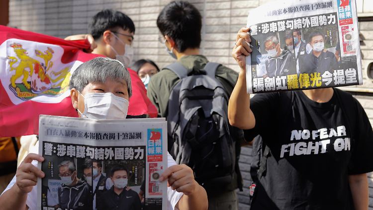 Protestierende am 19. Juni mit einer Ausgabe des "Apple Daily" - sie demonstrieren gegen die Maßnahmen der Behörden gegen die Zeitung.