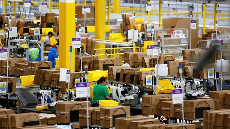 Amazon-Mitarbeiter stehen an Packstationen im Fulfillment Center in Kent im US-Bundesaat Washington.