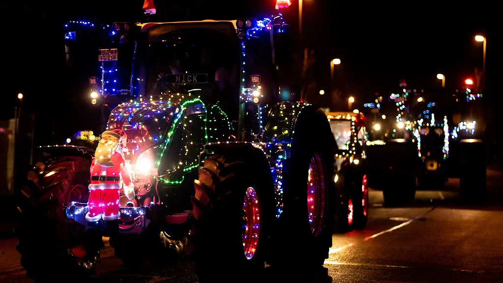 Weihnachtlich-geschmueckte-Traktoren-fahren-zu-Beginn-einer-Lichterfahrt-durch-eine-Strasse-Im-Kreis-Borken-wollen-die-Landwirte-am-Samstag-und-Sonntag-feierliche-Stimmung-verbreiten