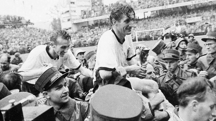 Fritz Walter (re.) lässt sich mit dem Pokal auf Schultern tragen, dahinter Horst Eckel.
