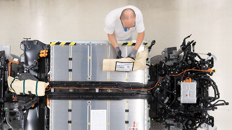 Ein VW-Mitarbeiter verkabelt den Akku an einer Linie für den VW ID.3.