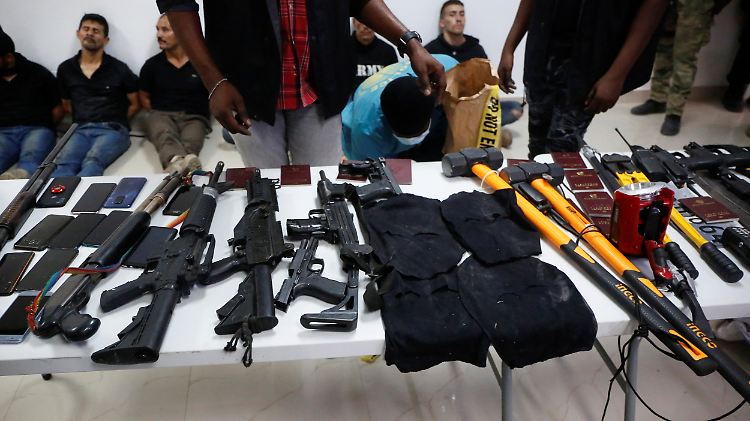 Auf einer Pressekonferenz präsentiert die Polizei sichergestellte Waffen und auch die mutmaßlichen Attentäter.