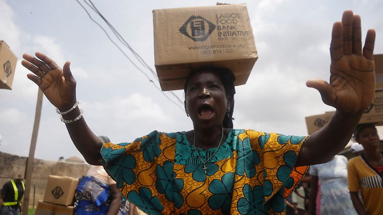 Eine Frau in Nigeria mit einem Lebensmittelpaket. Die Krise deckt Schwachstellen im Nahrungsmittelsystem auf.