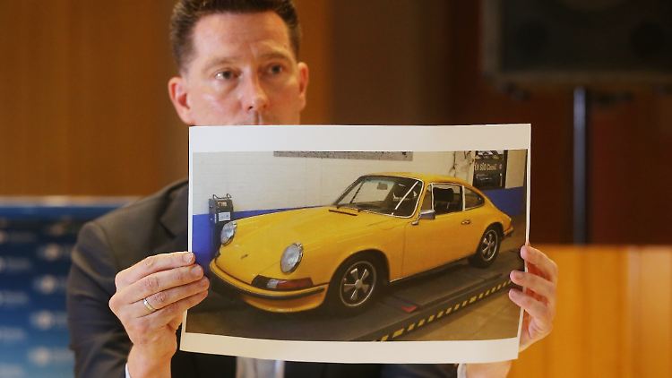 Ein Ermittler zeigt das Diebesgut: Die Bande hatte vor allem alte Porsche im Blick.
