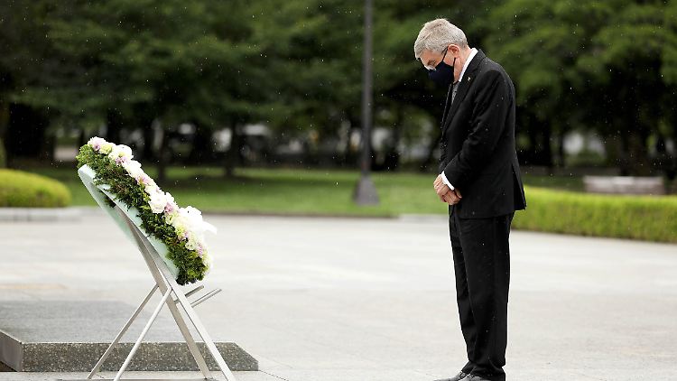 Thomas Bach legte bei der Gedenkstätte Hiroshimas Blumen nieder, vor der Tür warteten die Demonstranten.