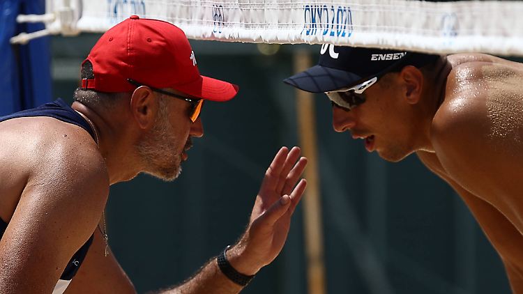 Der erschöpfte russische Beachvolleyballer Oleg Stojanowski (rechts) wird in der Tokio-Hitze von seinem Trainer eingeschworen.
