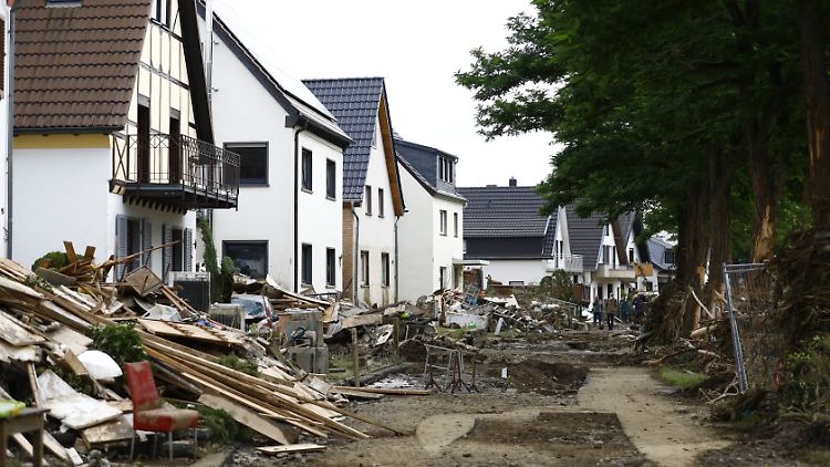 An den Straßenrändern türmen sich die Überreste der Flut-Folgen.