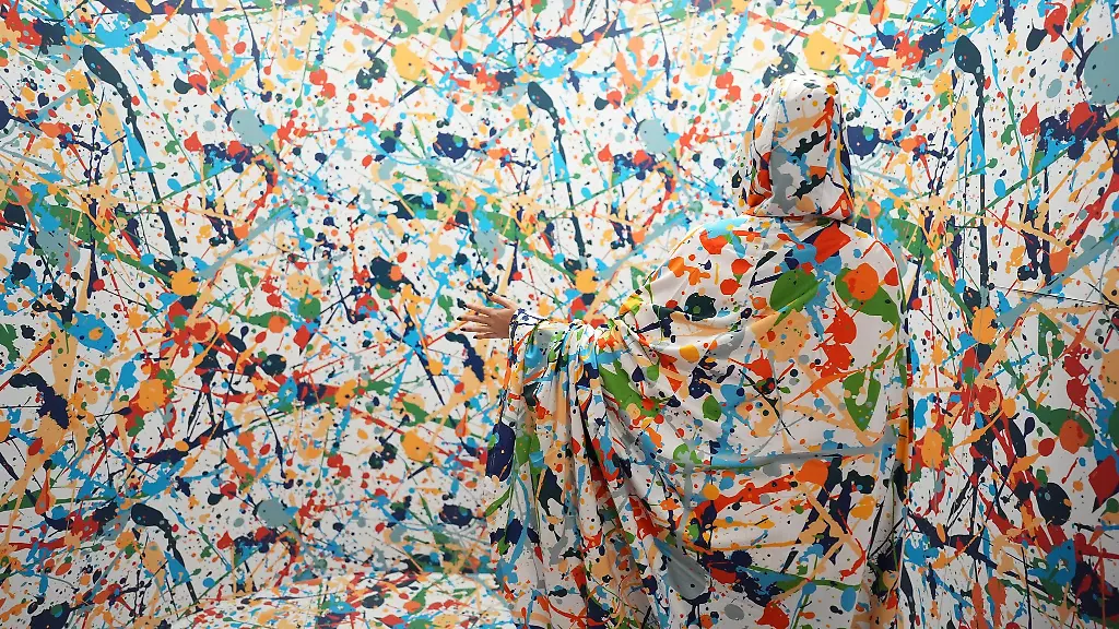 Ein-Umhang-laesst-eine-Besucherin-in-einer-optischen-Taeuschung-unsichtbar-erscheinen