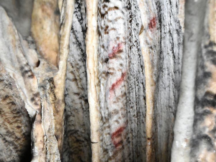 Nahaufnahme einer Säule mit roten Markierungen in der Cueva de Ardales.