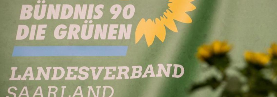 Das Logo des Landesverbandes Saarland Bündnis 90/Die Grünen ist auf einem Transparent zu sehen. Foto: Oliver Dietze/dpa/Archivbild