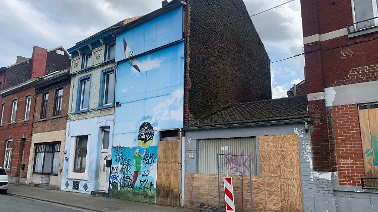 Ein verbarrikadierter Eingang und ein Bild eines Kindes, das einen Drachen in die Luft steigen lässt, an der Fassade des Hauses, in dem Marc Dutroux seine grausigen Taten verübte. 