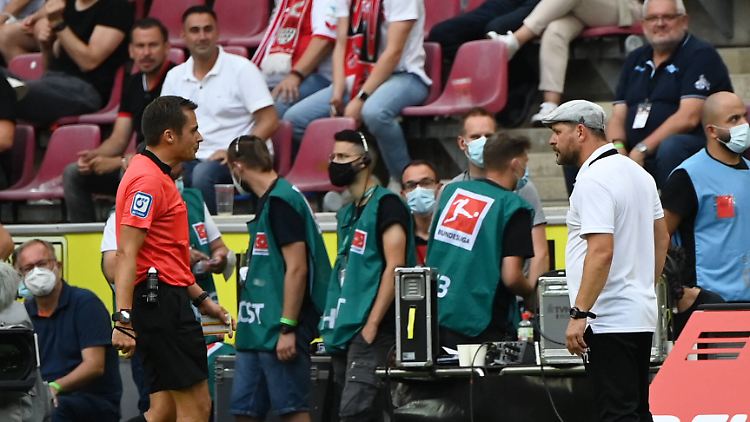 Schiedsdrichter Robert Hartmann und Köln-Trainer Steffen Baumgart treffen sich für ein Gespräch an der Seitenlinie. 