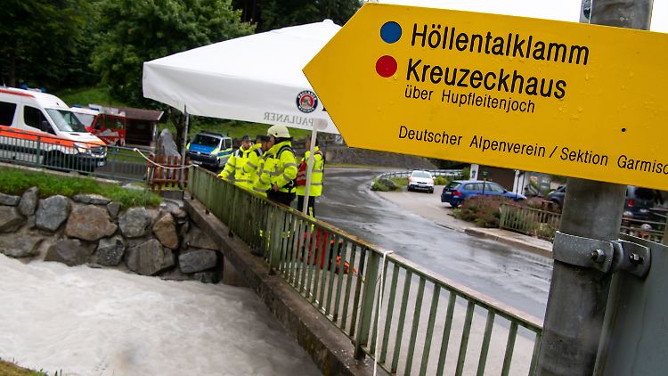 Mitglieder der Feuerwehr stehen nach einer Flutwelle in der Höllentalklamm bereit, um eventuell Opfer aus dem Fluss Hammersbach zu bergen.