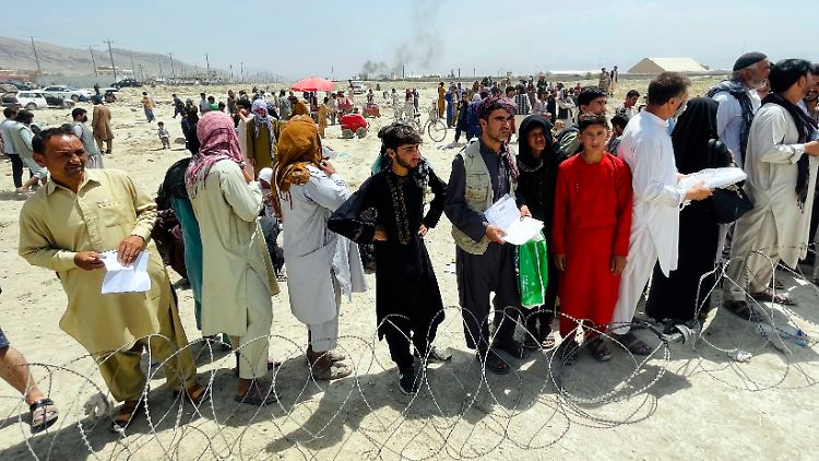 Hunderte von Menschen versammeln sich vor dem internationalen Flughafen in Kabul.