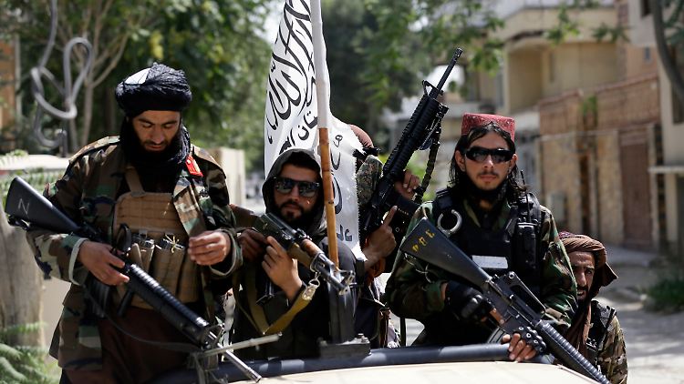 Taliban-Kämpfer mit amerikanischen M16 und AK-47 (Mitte).