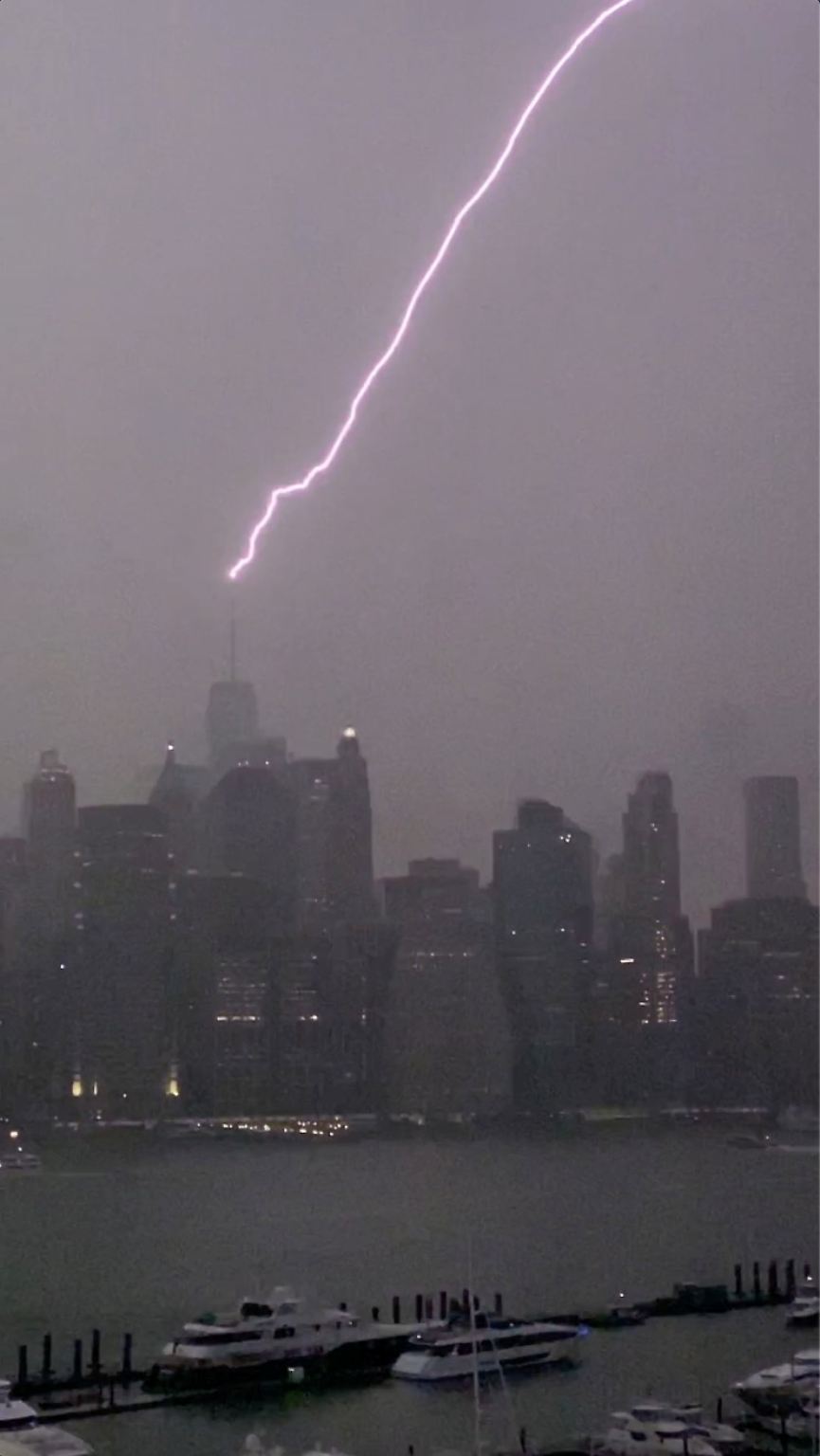 Ein Blitz schlägt ins New Yorker One World Trade Centre ein, Hurrikan "Henri" schiebt dicke Regenwolken über die US-Metropole.