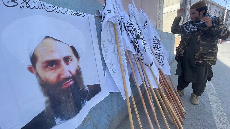 Zeichen des Siegs über den Westen: Nahe der evakuierten US-Botschaft in Kabul verteilen die Taliban Flaggen und hängen Plakate auf.