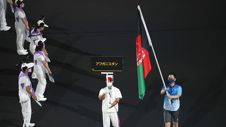 Bei der Eröffnungsfeier wird die Fahne Afghanistans von einem Volunteer ins Stadion getragen.