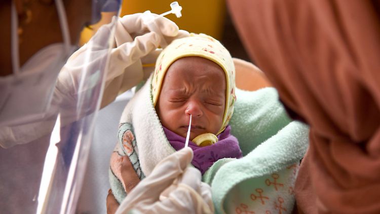 Ein Baby in einem indischen Krankenhaus muss einen Nasenabstrich für einen Corona-Test über sich ergehen lassen: In ärmeren Ländern hat die Pandemie größeren Einfluss auf die Geburtenrate.