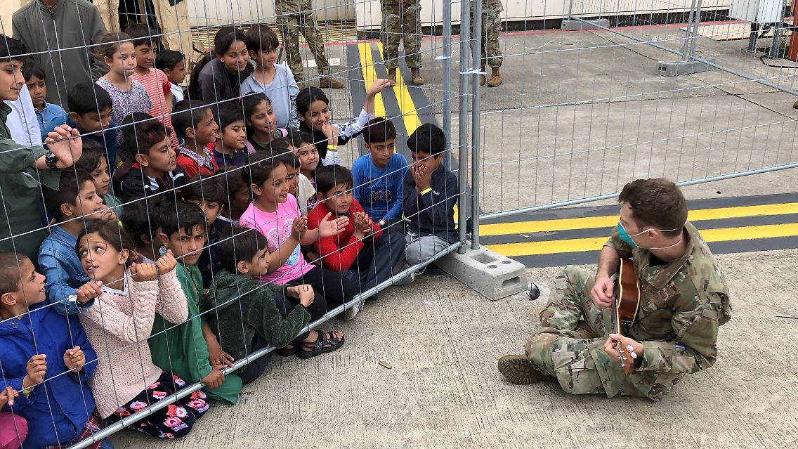 Ein US-Soldat spielt Ukulele auf der Ramstein Airbase für Kinder, die aus Afghanistan evakuiert wurden.