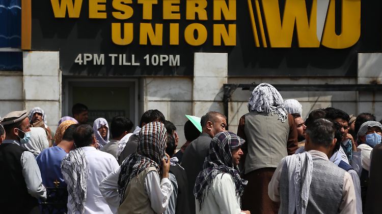 Zahlreiche Afghanen stehen vor einem Bankgebäude in Kabul Schlange.