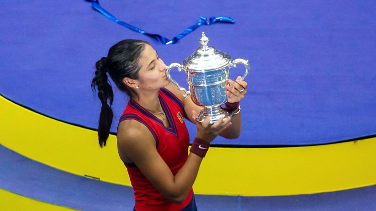 Emma Raducanu küsst ihre US-Open-Trophäe nach einem herausragenden Turnier.