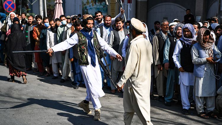 Taliban versuchen die Menschenmengen vor den Banken zu kontrollieren. 