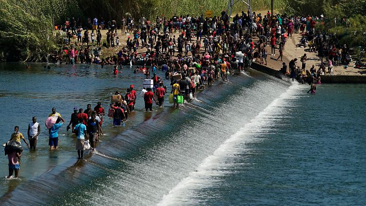 Haitianer passieren den Grenzfluss Rio Grande über einen Damm.