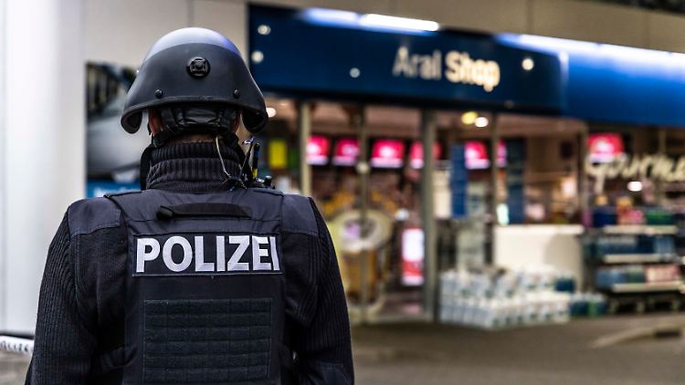Ein Polizist steht vor der Tankstelle in Idar-Oberstein.