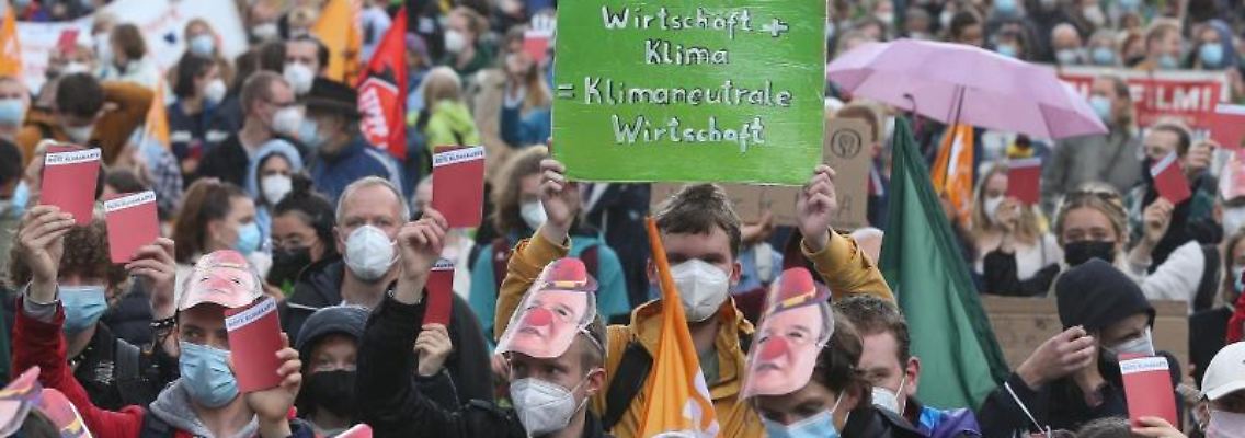 Demonstranten mit Plakaten. Foto: David Young/dpa/Symbolbild