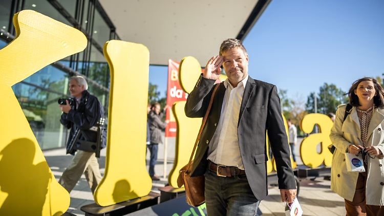 Grünen-Chef Robert Habeck freut sich über schöne Tage und spaziert zu den Dreiergesprächen mit SPD und FDP.