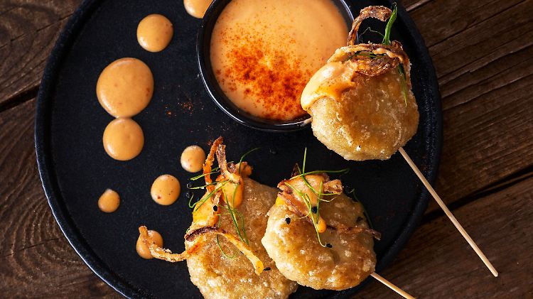 Die radikale Interpretation der klassischen Tiroler Kasspatzln: Kässpatzen-Lollypops mit Chili-Cheese-Mayo und Röstzwiebeln.