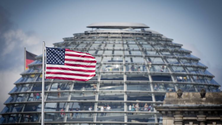 Die US-Flagge der US-Botschaft weht vor der Reichstagskuppel.