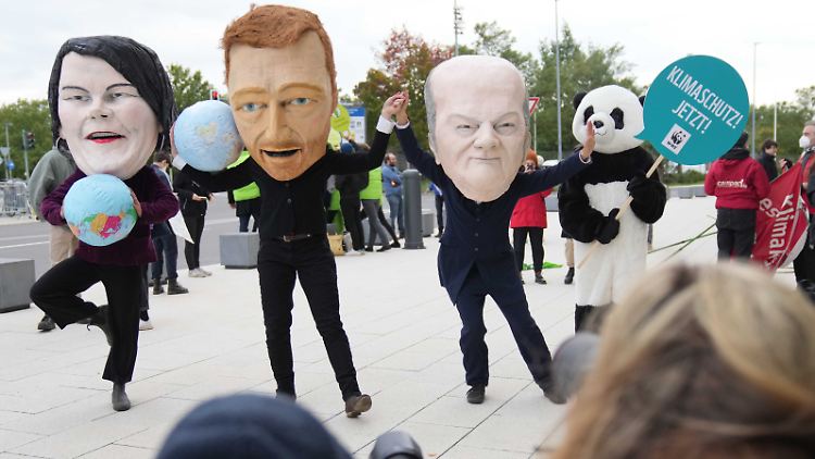 Aktivisten protestieren mit Masken, die Annalena Baerbock (l), Christian Lindner (2.v.l.) und Olaf Scholz darstellen sollen. Bei den ambitionierten Zielen der Ampel-Koalitionäre ist auch finanzielle Keeativität gefragt.