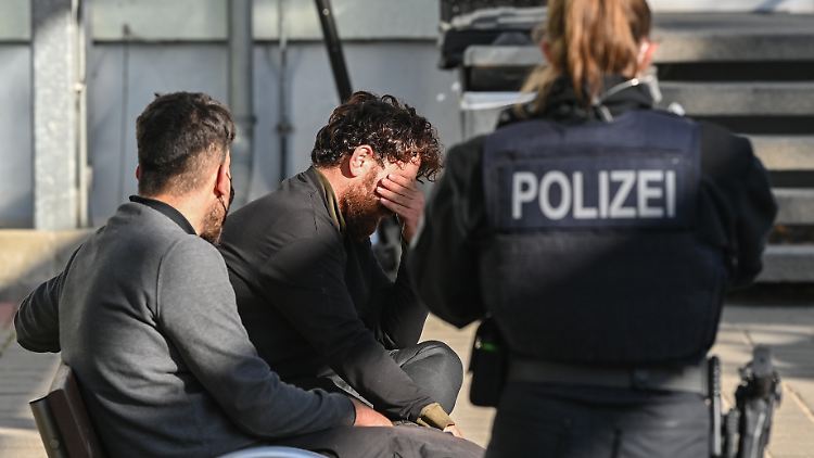 Eine Bundespolizistin bewacht zwei Migranten, die in Frankfurt an der Oder aufgegriffen worden sind. 