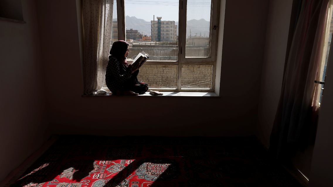 Um die Tage auszufüllen und sich zu beschäftigen, sitzt Hawa an einem Fenster im Hauses ihrer Familie in Kabul und liest ein Buch.