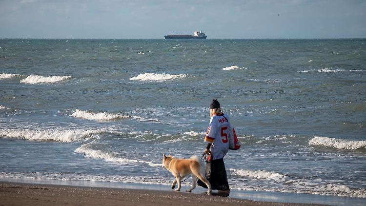 Eine Iranerin führt ihren Hund am Kaspischen Meer Gassi.