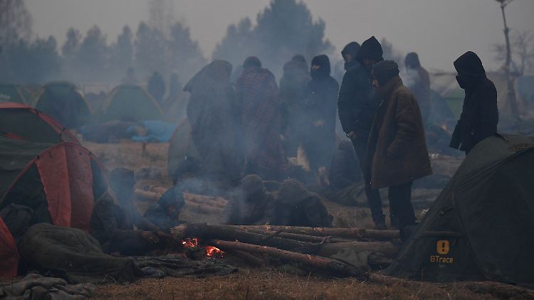 Flüchtlinge im Camp am Grenzübergang Kuznica-Brusgi wärmen sich an einem Feuer. Einige der Migranten können die Grenze bald verlassen.