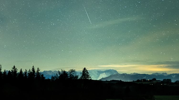 Eine Sternschnuppe verglüht über dem Alpenpanorama. Die Geminiden sind der stärkste Meteorstrom des Jahres.