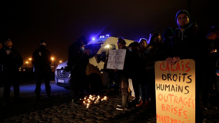 Aktivisten und Mitglieder von Vereinen, die sich für die Rechte von Migranten einsetzen, versammelten sich nach dem Unglück mit Plakaten vor dem Hafen von Calais.