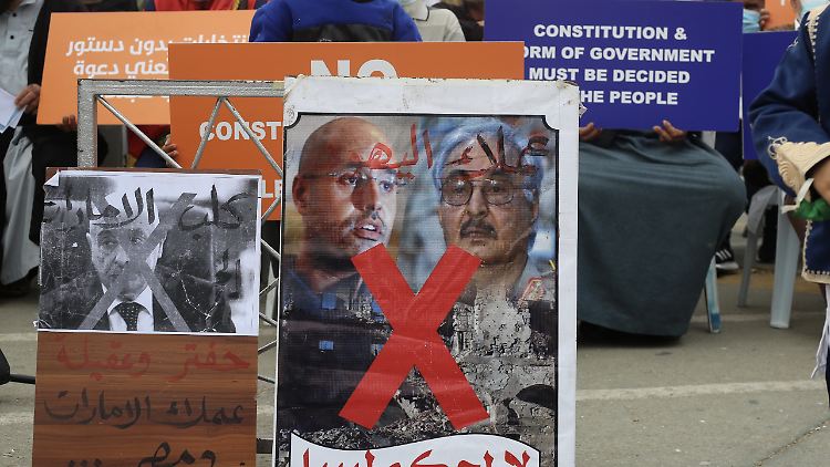 Demonstranten protestieren gegen die Kandidatur von Saif al-Islam Gaddafi, der auf dem Plakat in Farbe neben dem älteren General Chalifa Haftar abgebildet ist.