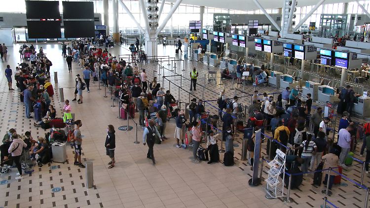 An den wenigen Schaltern, die am Flughafen in Kapstadt noch geöffnet sind, warten Passagiere lange für ihren Flug nach Deutschland.