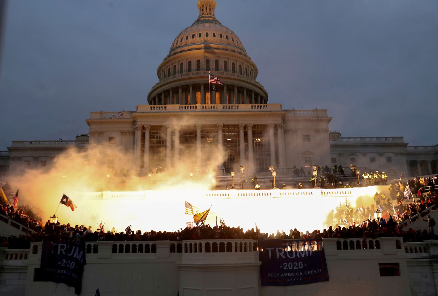6. Januar: Eine Explosion, die offenbar von Polizeimunition ausgelöst wurde, erleuchtet die Treppen vor dem Kapitol in Washington. Anhänger des abgewählten Präsidenten Donald Trump greifen den Kongress gewaltsam an. Zahlreiche Demonstranten stürmen das Gebäude.