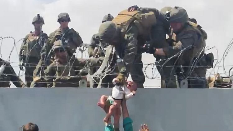 Pure Verzweiflung: Ein Baby wird über den Zaun des Kabuler Flughafens US-Soldaten übergeben, damit sie es außer Landes schaffen.