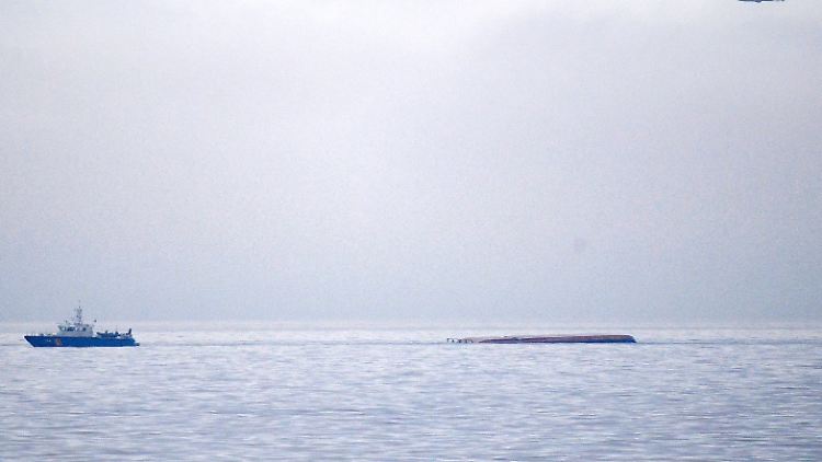 Ein Rettungsboot fährt an dem gekenterten dänischen Frachtschiff Karin Hoej vorbei.