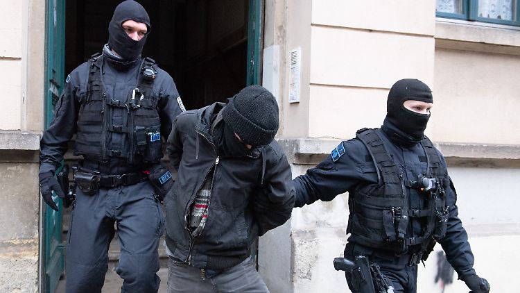 Polizisten führen bei einer Razzia im Stadtteil Pieschen einen Tatverdächtigen aus einem Hauseingang. 