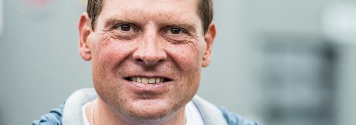 Der ehemalige Radrennprofi Jan Ullrich steht am Straßenrand. Foto: Guido Kirchner/dpa/Archivbild