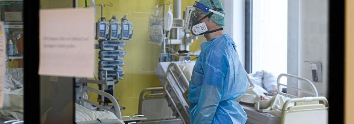 Ein Pfleger versorgt auf einer Covid-19-Intensivstation Corona-Patienten. Foto: Robert Michael/dpa-Zentralbild/dpa/Symbolbild
