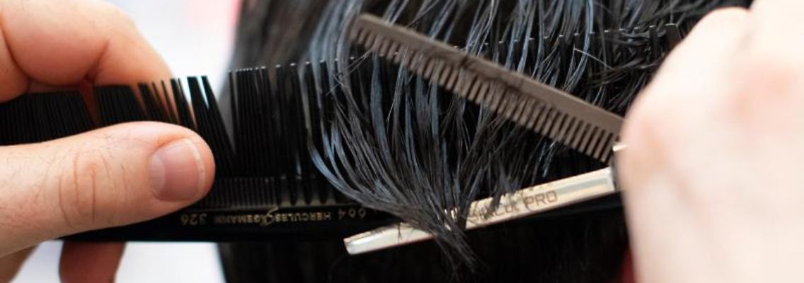 Ein Friseur schneidet einer Kundin mit einer Schere die Haare in einem Friseur-Salon. Foto: Symbolbild Friseur/dpa/Symbolbild